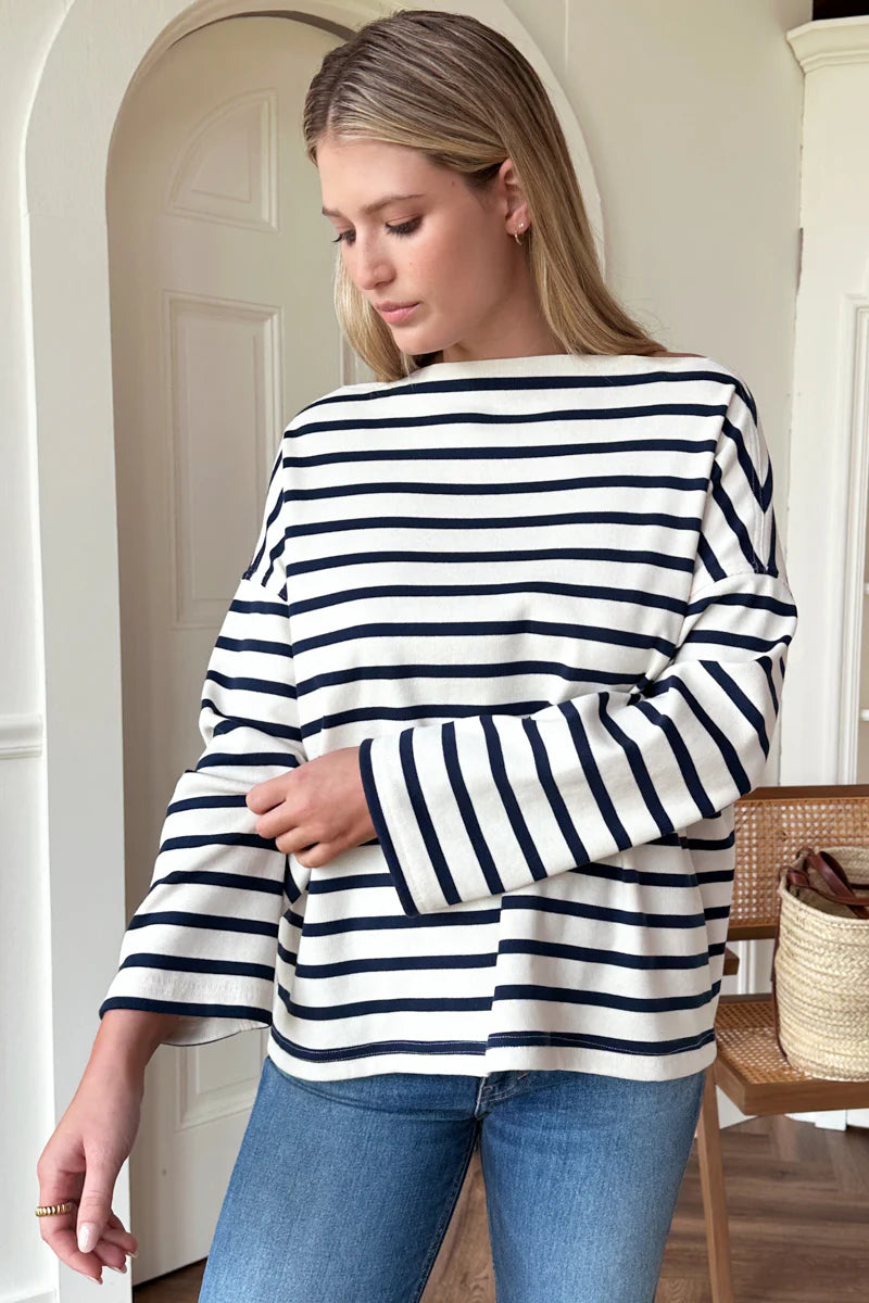 Image of model wearing Emerson Fry Bateau Top in Navy Stripe. Bateau top is a cotton rib boatneck top with dropped shoulder and boxy body in a classic white and navy blue stripe. 