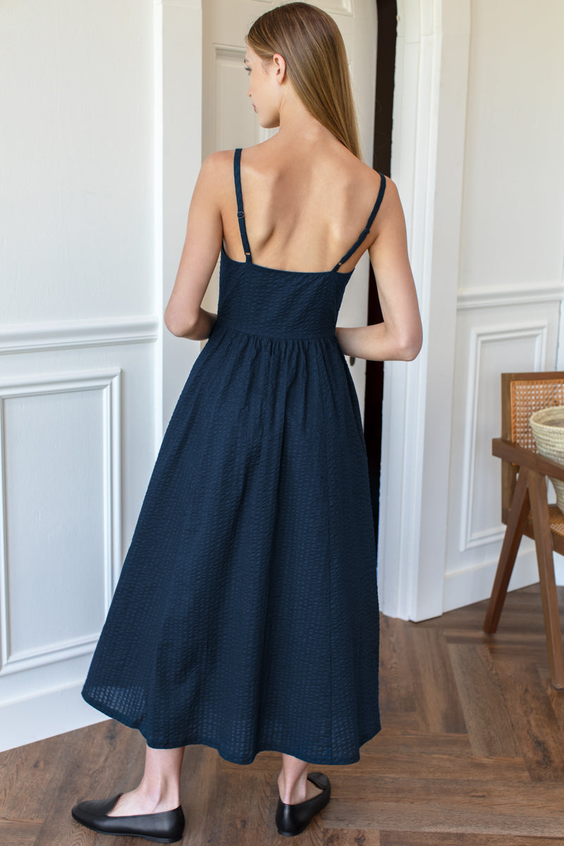 Image of model wearing Emerson Fry Florentine Layering Dress in Navy Seersucker. Florentine Dress is a spaghetti strap dress with sweetheart bodice and full, a-line skirt. Designed and made in the USA. 