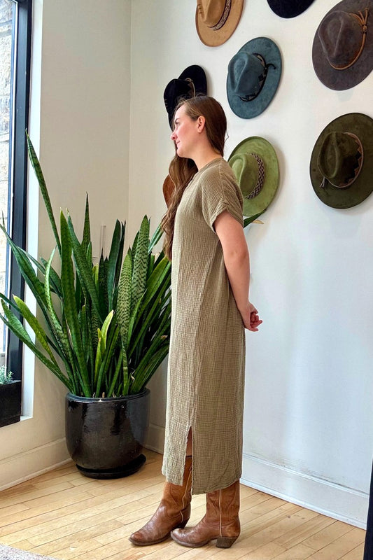 Image of IT IS WELL LA Mandarin Gauze Midi Dress in Olive. This loose fitting dress is made from an organic cotton crinkled Gauze, hits midi length with symmetrical side slits, rolled short sleeve, and open Mandarin collar. Made in USA.