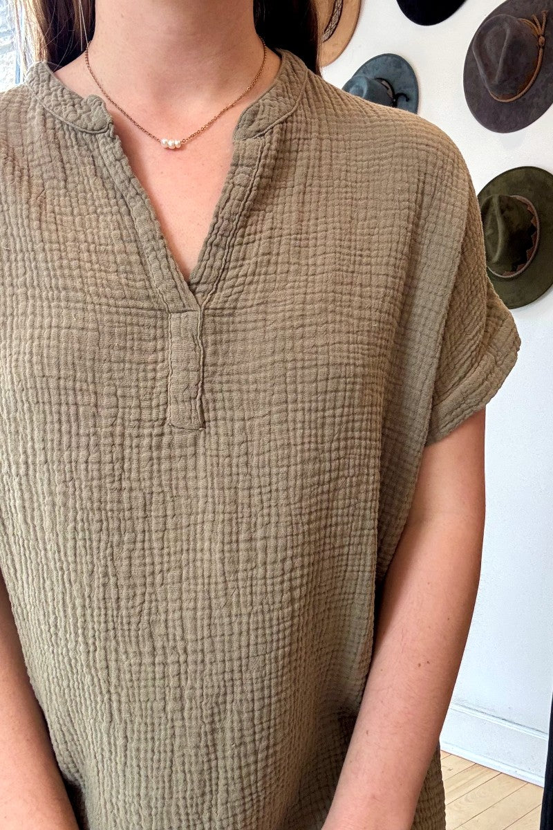 Image of IT IS WELL LA Mandarin Gauze Midi Dress in Olive. This loose fitting dress is made from an organic cotton crinkled Gauze, hits midi length with symmetrical side slits, rolled short sleeve, and open Mandarin collar. Made in USA. 