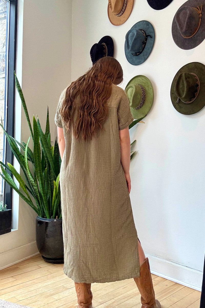 Image of IT IS WELL LA Mandarin Gauze Midi Dress in Olive. This loose fitting dress is made from an organic cotton crinkled Gauze, hits midi length with symmetrical side slits, rolled short sleeve, and open Mandarin collar. Made in USA. 