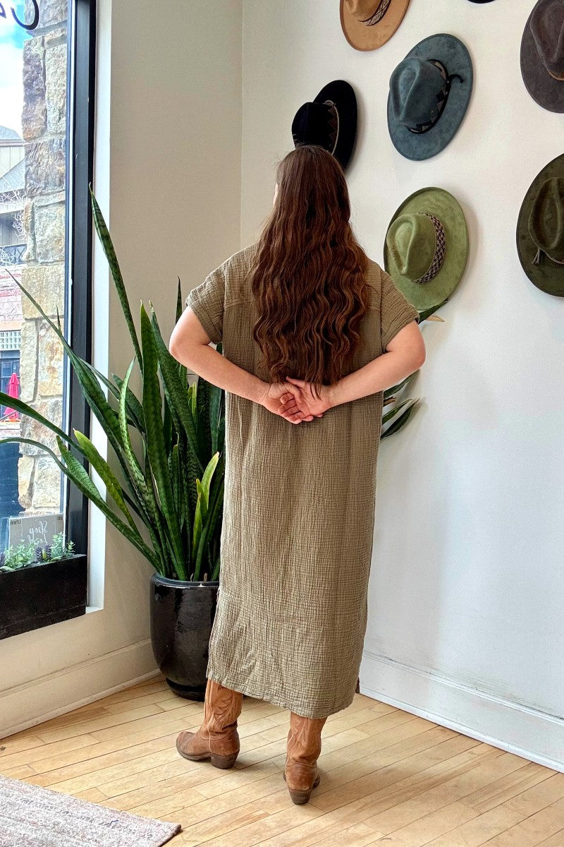 Image of IT IS WELL LA Mandarin Gauze Midi Dress in Olive. This loose fitting dress is made from an organic cotton crinkled Gauze, hits midi length with symmetrical side slits, rolled short sleeve, and open Mandarin collar. Made in USA. 