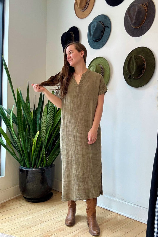 Image of IT IS WELL LA Mandarin Gauze Midi Dress in Olive. This loose fitting dress is made from an organic cotton crinkled Gauze, hits midi length with symmetrical side slits, rolled short sleeve, and open Mandarin collar. Made in USA.