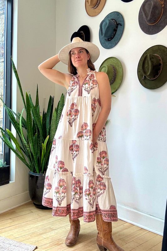 Image of model wearing MAELU DESIGNS Poppy Tiered Sundress. Poppy dress is a halter style sundress with flowing, tiered a line skirt, v-neck opening, and frilled bodice in a hand block printed Mischa Floral Cotton. 