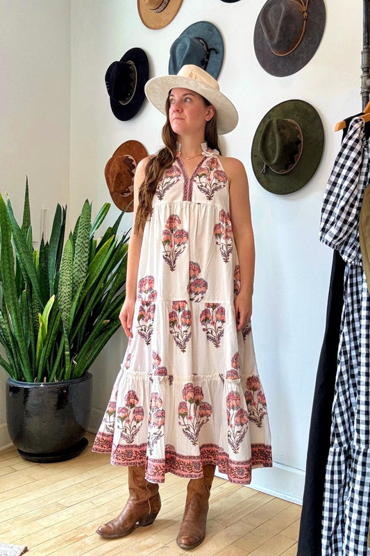 Image of model wearing MAELU DESIGNS Poppy Tiered Sundress. Poppy dress is a halter style sundress with flowing, tiered a line skirt, v-neck opening, and frilled bodice in a hand block printed Mischa Floral Cotton. 