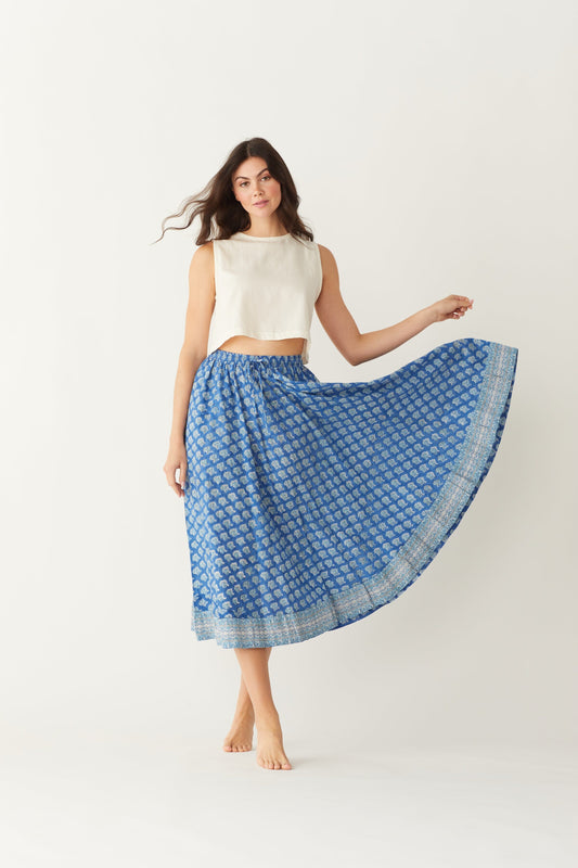 Image of model wearing MAELU DESIGNS Pull-On Drawstring Midi Skirt in Willow Ikat Print. Willow Print is a blue Ikat inspired floral print hand block printed on lightweight cotton.