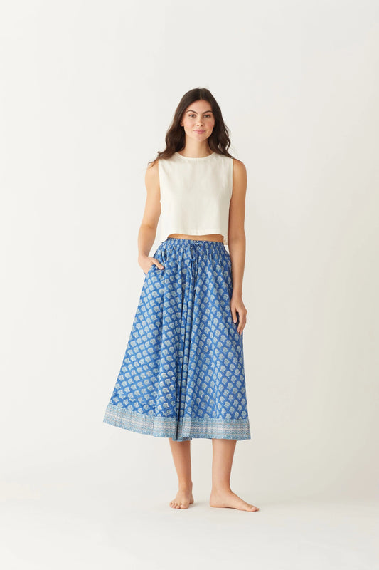 Image of model wearing MAELU DESIGNS Pull-On Drawstring Midi Skirt in Willow Ikat Print. Willow Print is a blue Ikat inspired floral print hand block printed on lightweight cotton.