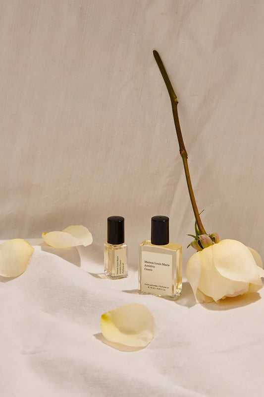 MAISON LOUIS MARIE Roll On Perfume Bottles in Shown in Studio with White Roses _ Antidris Cassis 0.5 fl oz personal fragrance