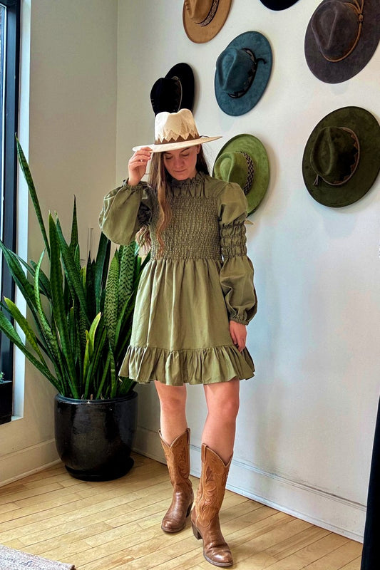 Image of NARY RESORT Pintuck Shirred Turtleneck Mini Dress in Army Green Linen. This dress has a fully shirred bodice, a-line skirt, ruffled collar and hemline, and a Victorian inspired sleeve that cinches over the bicep. Hits above the knee. Ethically made in Cambodia. 