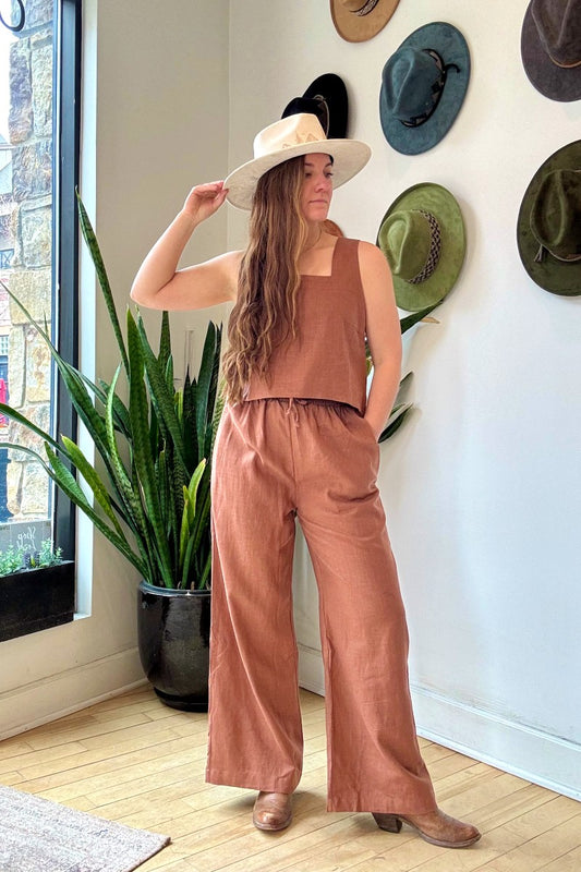Image of NARY RESORT Koh Rong Lounge Pant in Clay Deadstock Linen. These pants have a high rise, frilled drawstring waist, and a full inseam with a wide leg opening. Ethically made in Cambodia.