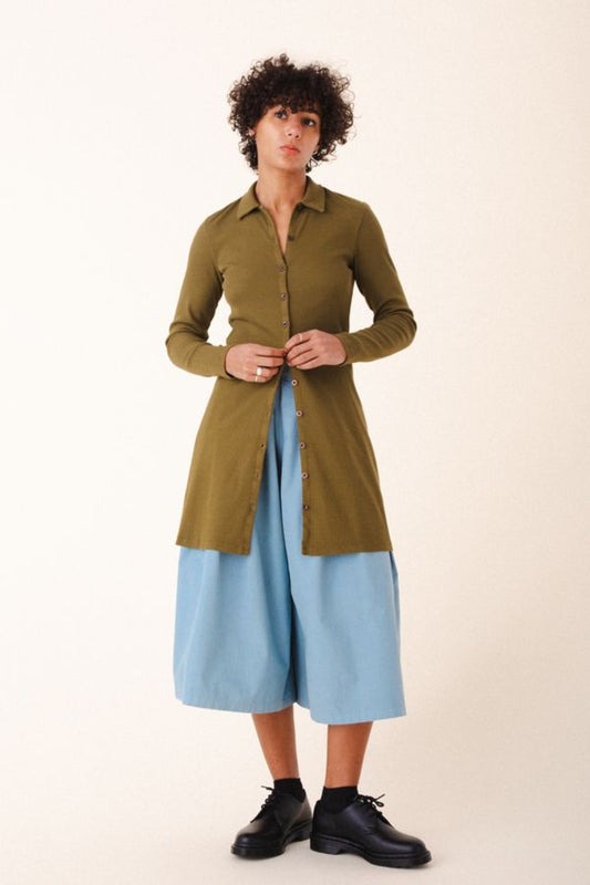 Image of model wearing Cavalos Shirt Dress in Herb Green Rib. Cavalos is a fitted shirt dess with a classic collar that hits mid-thigh made from organic cotton Ribbed fabric.