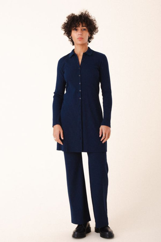 Image of model wearing Cavalos Shirt Dress in Midnight Rib. Cavalos is a fitted shirt dess with a classic collar that hits mid-thigh made from organic cotton Ribbed fabric.