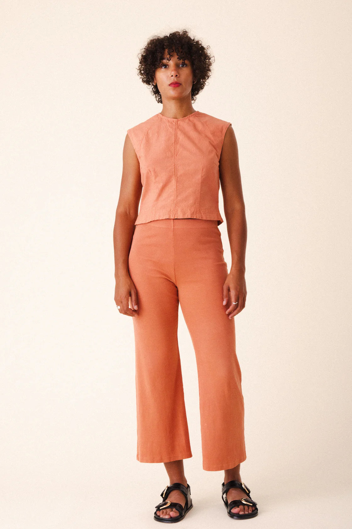 Image of model wearing Prairie Underground Interval Shell Top in Cedar Chest. Interval Top is a tailored sleeveless shell top with tonal darting through, made in Seattle, Washington from a Cedar Pink organic cotton muslin.