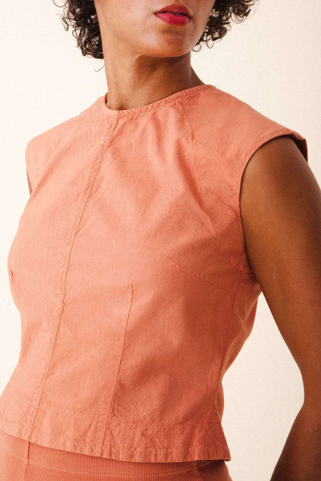 Image of model wearing Prairie Underground Interval Shell Top in Cedar Chest. Interval Top is a tailored sleeveless shell top with tonal darting through, made in Seattle, Washington from a Cedar Pink organic cotton muslin.