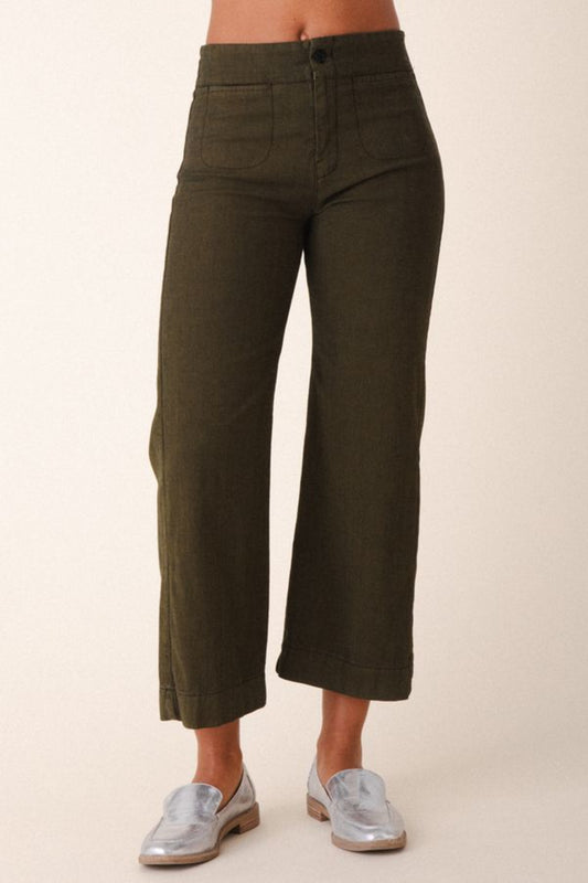 Image of model wearing Prairie Underground Document Jean in Herb Green. This zip fly Jean has a cropped inseam with a kick flare leg opening. Designed and made in USA.