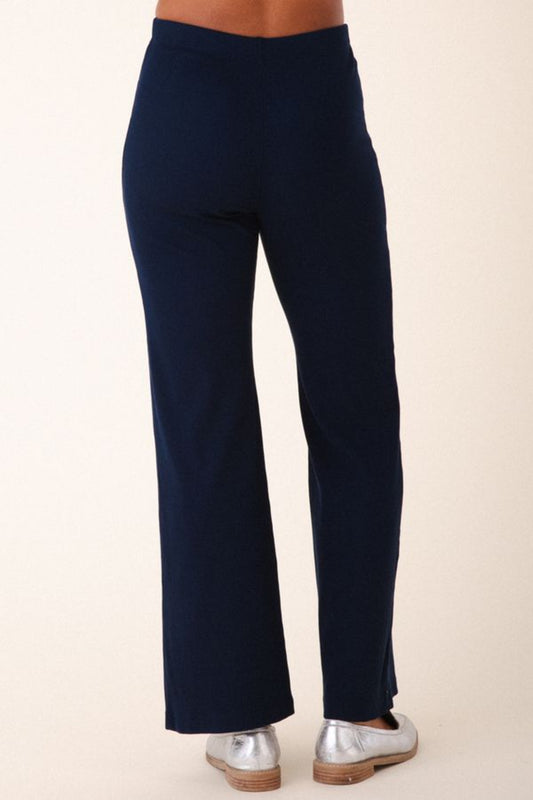 Image of model wearing Prairie Underground Easy Rider Pant in Midnight Rib. Easy Rider is a mid-rise flared, full length legging made from ribbed organic cotton fabric. Designed and made in USA.