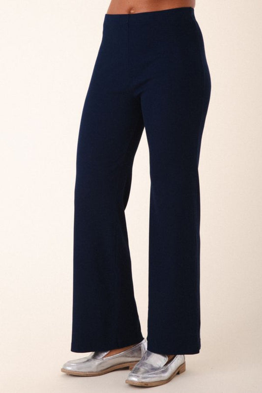 Image of model wearing Prairie Underground Easy Rider Pant in Midnight Rib. Easy Rider is a mid-rise flared, full length legging made from ribbed organic cotton fabric. Designed and made in USA.