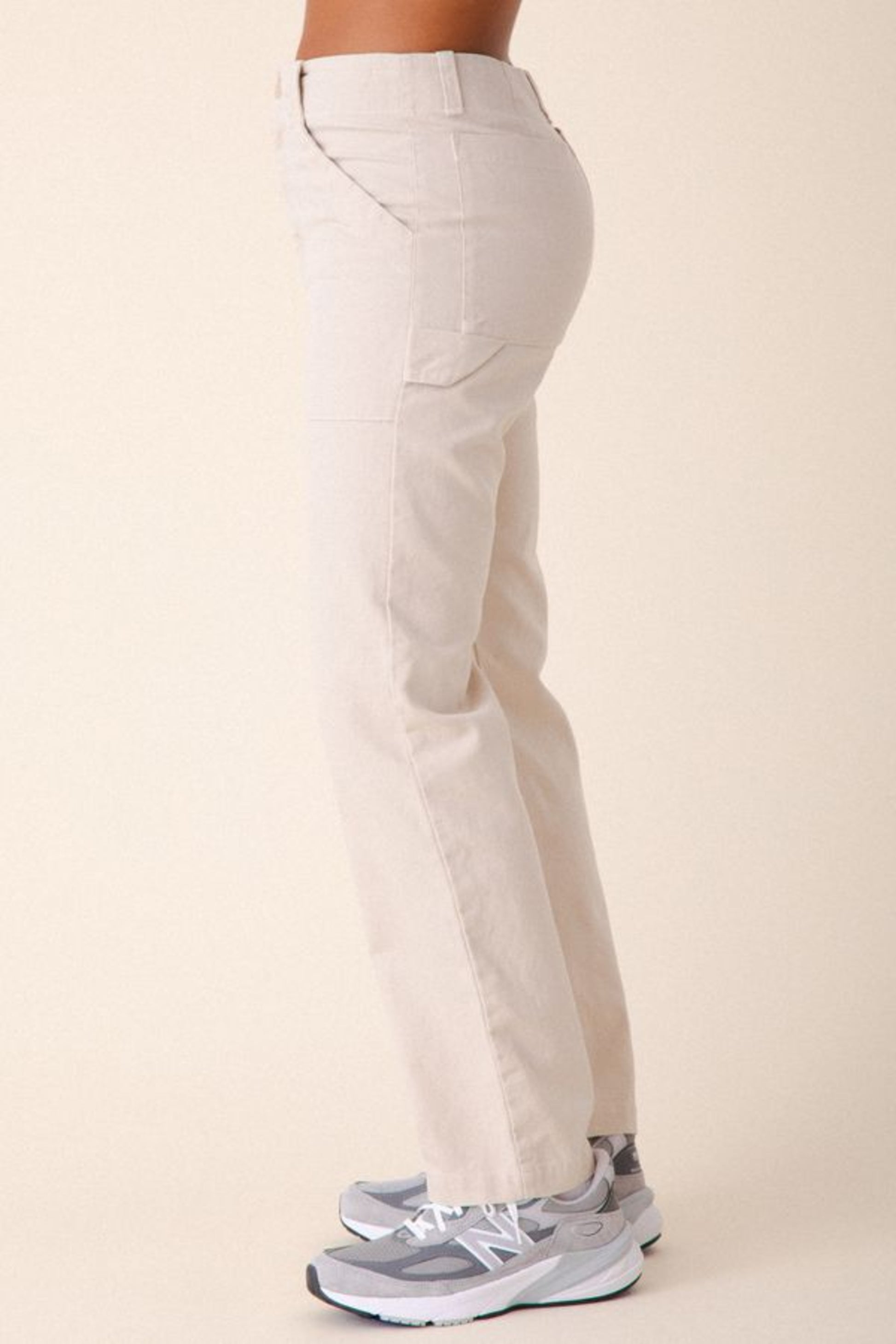 Image of model wearing Prairie Underground Utility Pant in Natural White Organic Cotton Canvas. Utility Pant is a work wear inspired style with a high rise and flattering fit. Designed and produced in Seattle, Washington, USA.