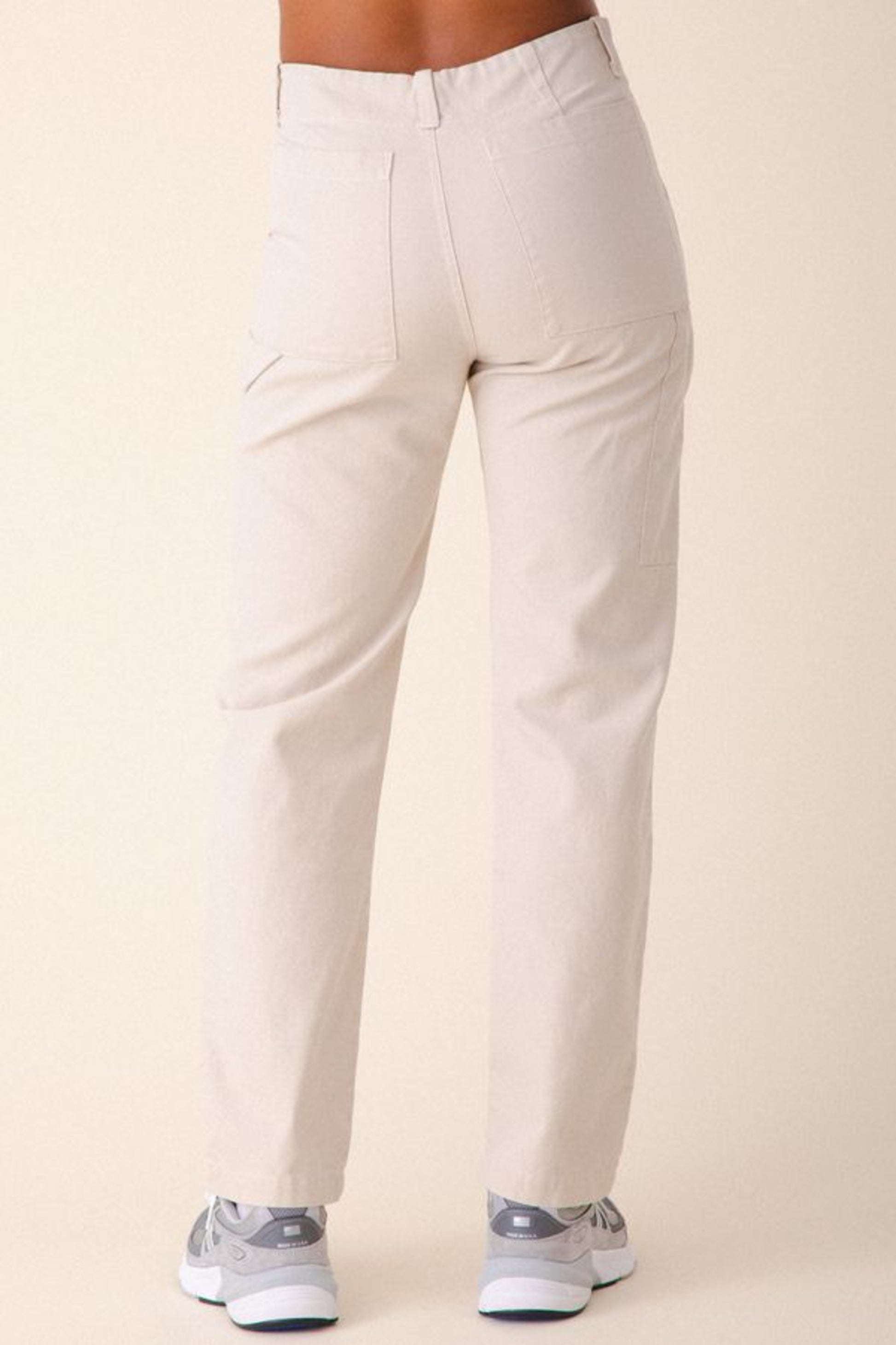 Image of model wearing Prairie Underground Utility Pant in Natural White Organic Cotton Canvas. Utility Pant is a work wear inspired style with a high rise and flattering fit. Designed and produced in Seattle, Washington, USA.