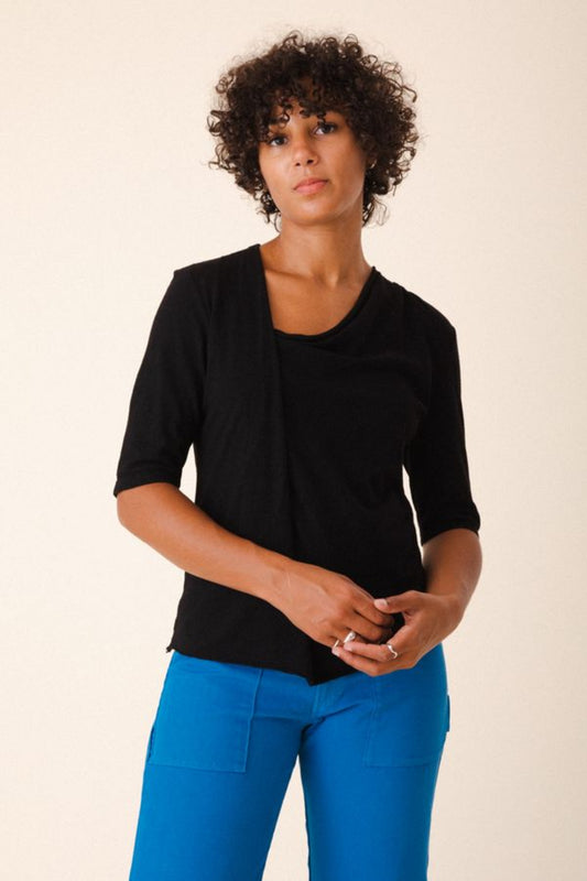 Image of model wearing Prairie Underground Gres Tee in Black. Gres Tee is an elbow length hemp t-shirt with an asymmetrical draped neckline. Designed and produced in Seattle, Washington.