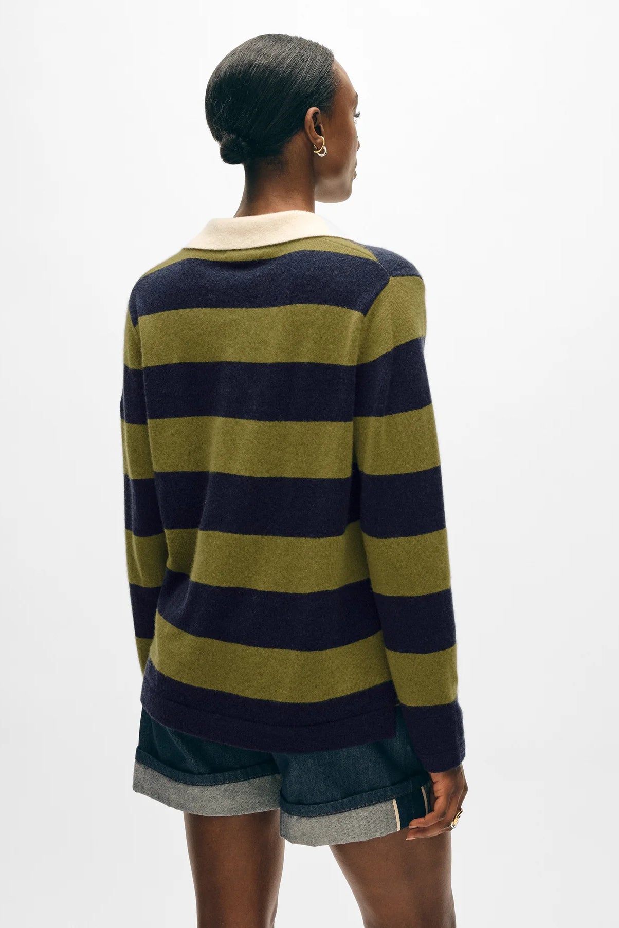 Image of model wearing White + Warren Cashmere Rugby Polo Sweater. This sweater has an oversized fit with all over navy and olive large stripping, contrast cream collar, and tortoise buttons on lapel.