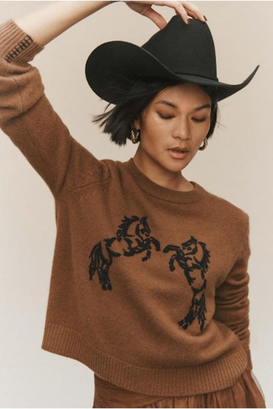 Image of model wearing White + Warren Embroidered Cashmere Wool Blend Sweater. Classic crewneck sweater with hand embroidered Horse motif on front. Black stitching on brown-tan background. Ethically made knitwear for women.