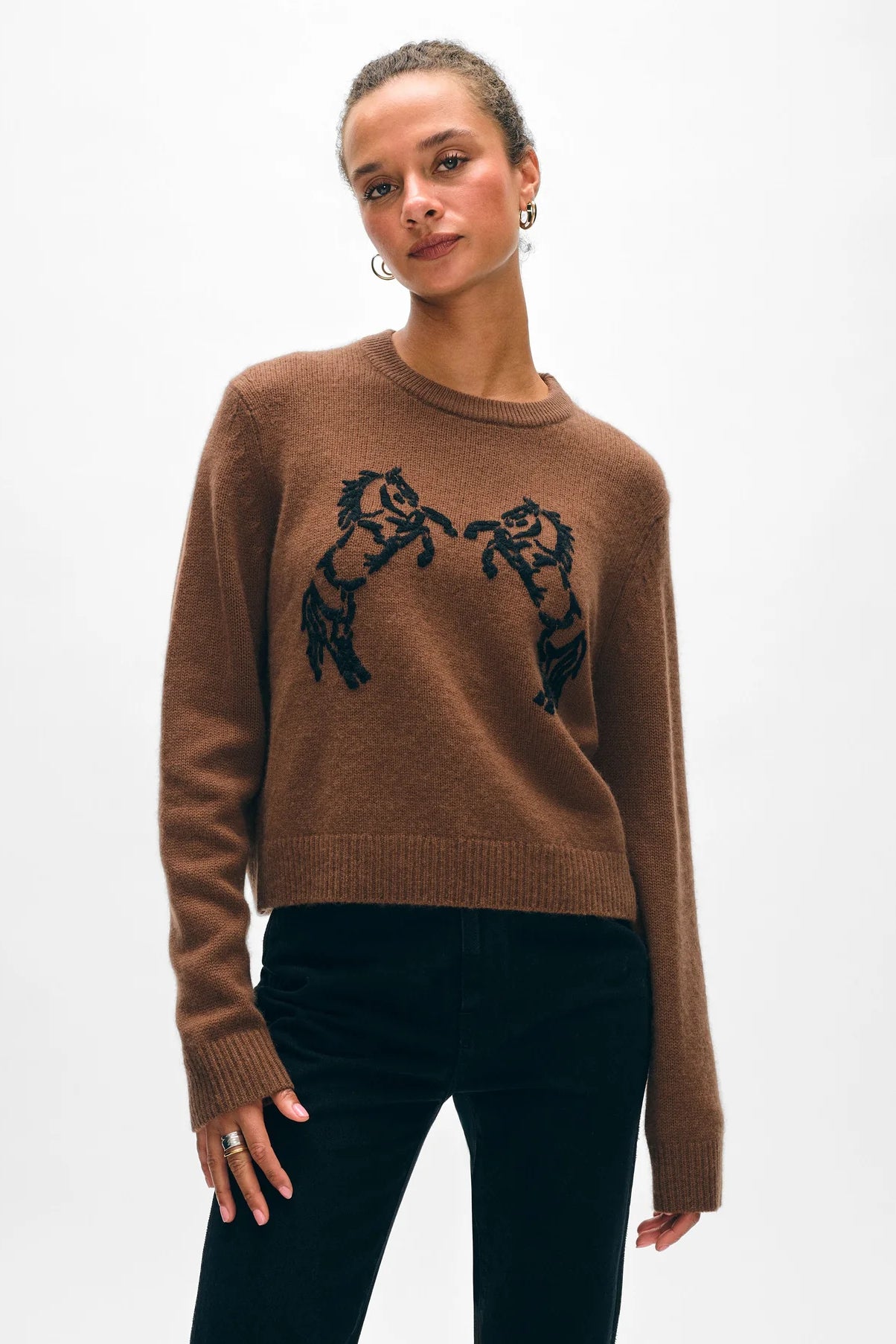 Image of model wearing White + Warren Embroidered Cashmere Wool Blend Sweater. Classic crewneck sweater with hand embroidered Horse motif on front. Black stitching on brown-tan background. Ethically made knitwear for women.